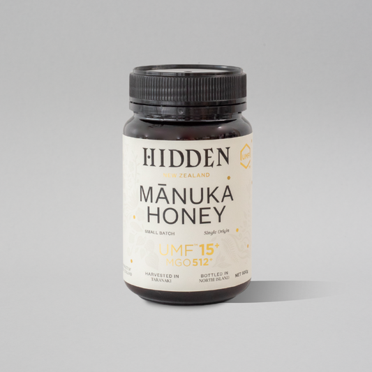 Jar of WellNest UMF15+ Manuka Honey with MGO512+ label, 500g container showing golden honey inside.