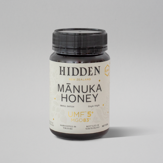 Jar of WellNest UMF5+ MGO83+ Manuka Honey 500g with golden honey visible in the clear glass jar.