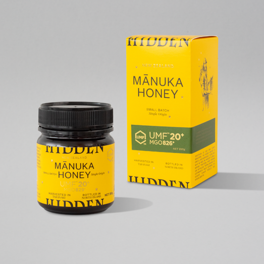 WellNest UMF20+ Manuka Honey 250g jar showing golden, thick honey with a white lid and label displaying UMF and MGO ratings.