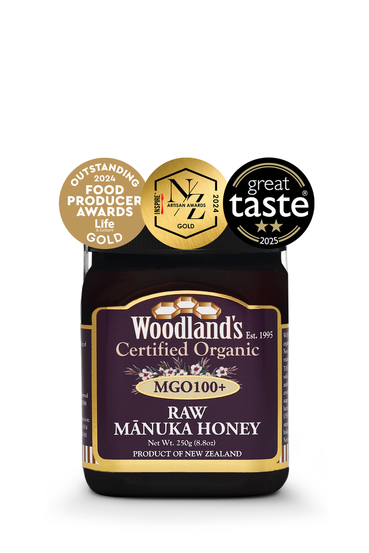 Jar of WellNest MGO100+ Organic Raw Manuka Honey in a 250g jar with gold label and 24+ UMF rating.