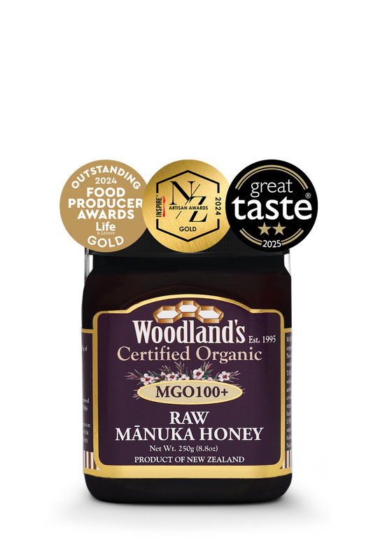 Jar of WellNest MGO100+ Organic Raw Manuka Honey in a 250g jar with gold label and 24+ UMF rating.