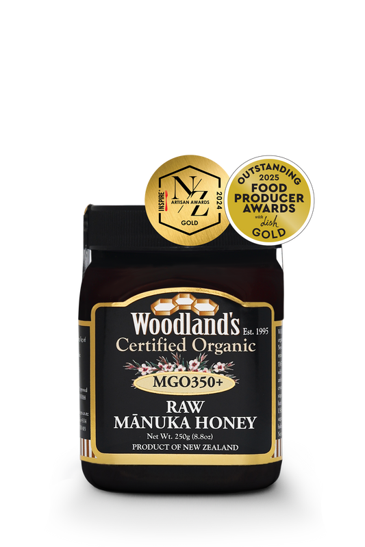 Jar of WellNest MGO350+ Organic Raw Manuka Honey with golden label and 250g size, showcasing thick, golden honey inside.