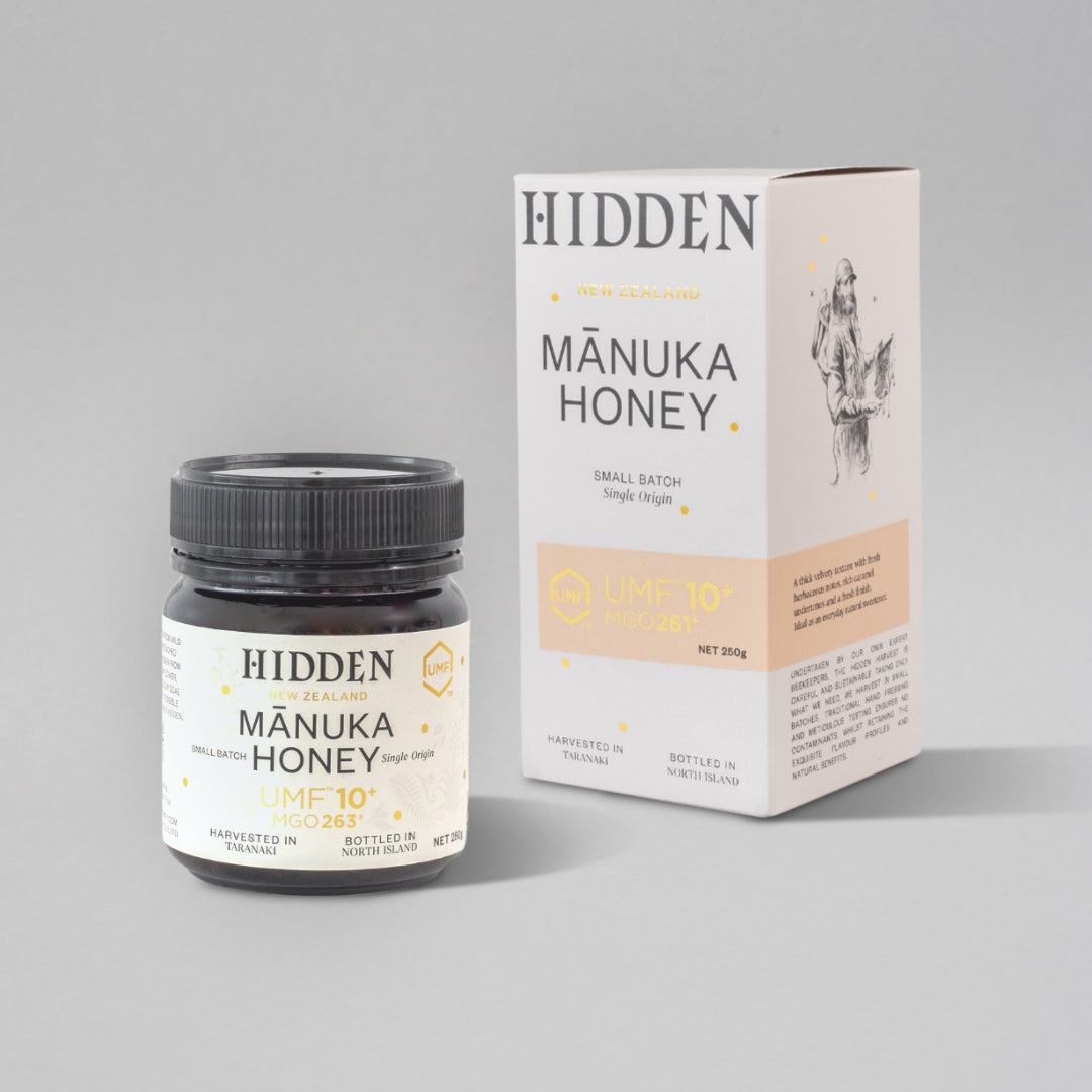 Jar of WellNest UMF10+ Manuka Honey with MGO263+ in a 250g glass container, showing the honey's rich, golden color.