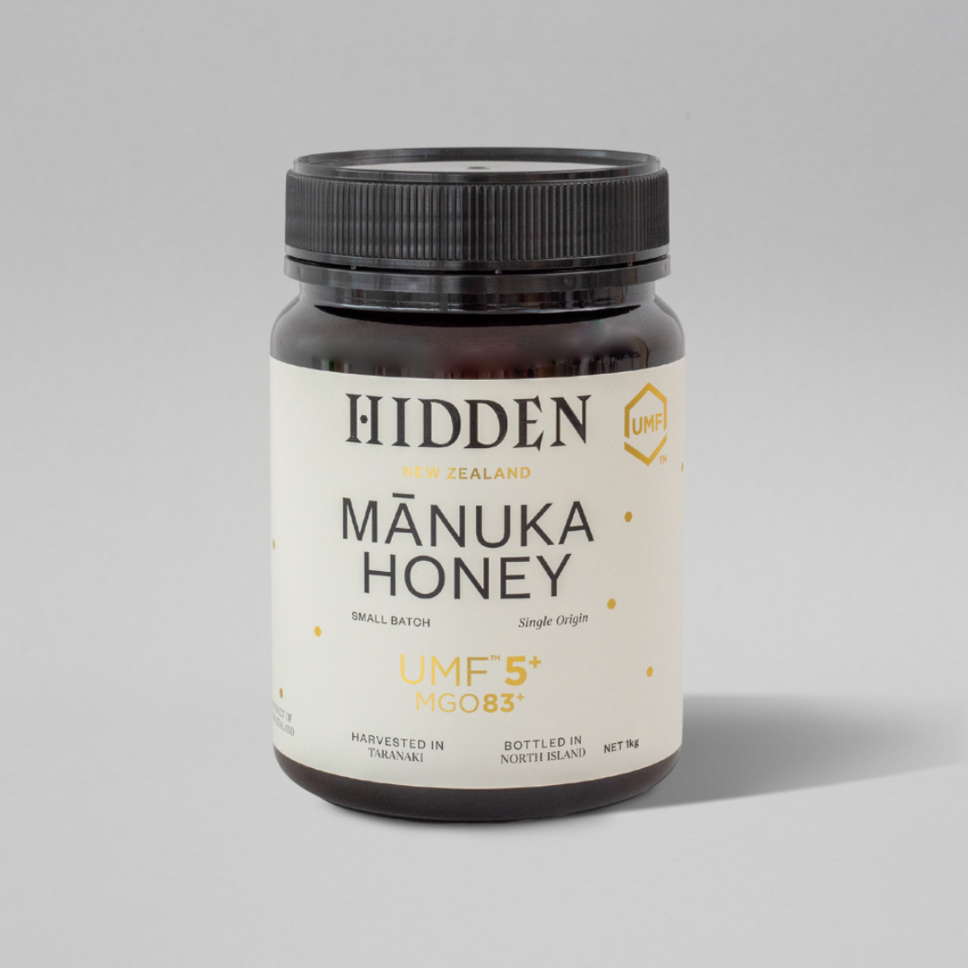 Jar of WellNest UMF5+ Manuka Honey with MGO83+ in a 1kg container, showcasing the honey's rich, golden texture and label.
