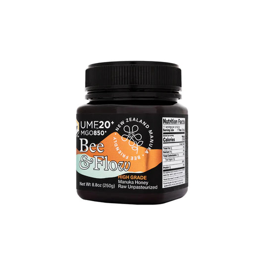WellNest Bee & Flow Raw Manuka Honey UMF 20+ MGO 850+ jar with golden honey, labeled UMF 20+ on the front.