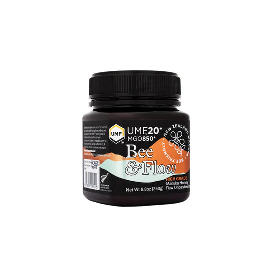 Jar of WellNest Bee & Flow Raw Manuka Honey UMF 20+ MGO850+ with natural honey texture and label visible.