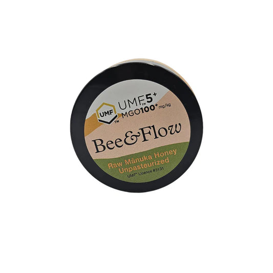 Jar of WellNest Bee & Flow Raw Manuka Honey UMF 5+ with MGO 100+ in a glass jar, showing the honey’s golden color and label.