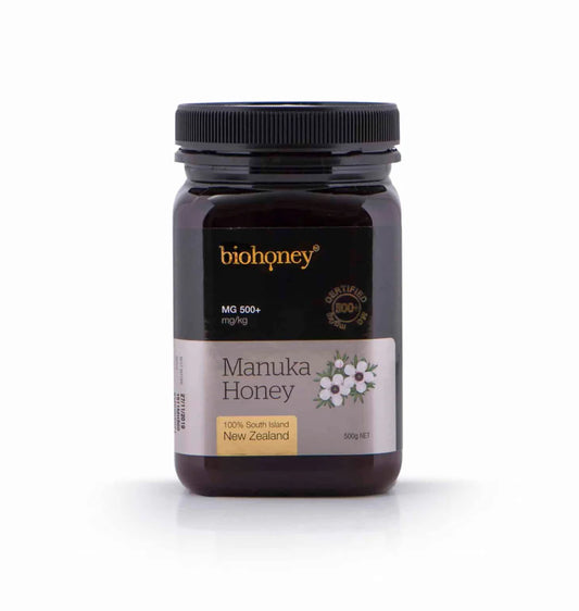 WellNest Mānuka Honey MGO 500+ in a 500g jar, showcasing the golden, thick honey with a natural honeycomb background.