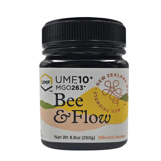 Jar of WellNest Manuka Honey UMF10+ with MGO263+ showing golden honey in a clear glass jar with a white lid.