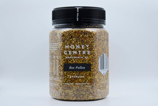 WellNest bee pollen granules in a clear jar, close-up view showing yellow pollen granules for natural bee pollen supplement.
