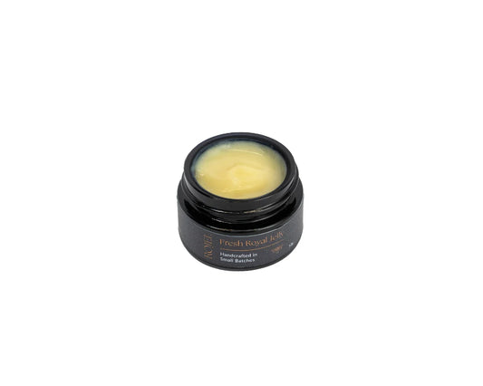Fresh New Zealand Royal Jelly in a 100g jar by WellNest, showing the golden, creamy royal jelly in a clear glass container.